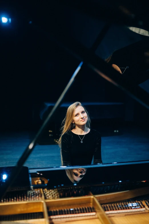 a woman sitting at a piano in a dark room, a portrait, by Anna Haifisch, antipodeans, on white background, smug smile, performing on stage, asya yoranova and alan lee