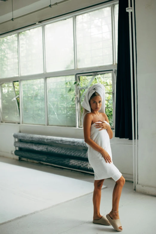 a little girl standing in a room with a towel on her head, inspired by Elsa Bleda, unsplash, happening, model with attractive body, manuka, white, full - length photo