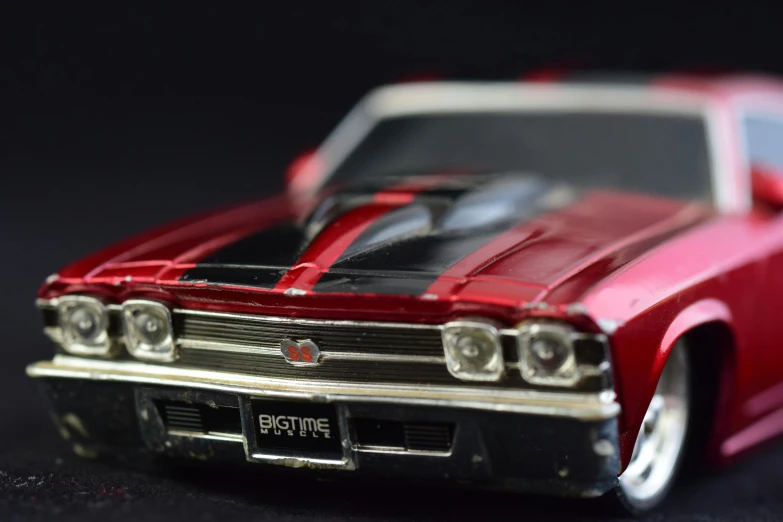 a close up of a toy car on a table, by Tom Bonson, pexels contest winner, photorealism, muscle cars, chrome red, rectangle, black car