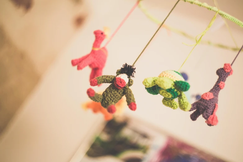 a group of stuffed animals hanging from strings, pexels contest winner, kinetic art, claymation, crochet, ilustration, small depth of field