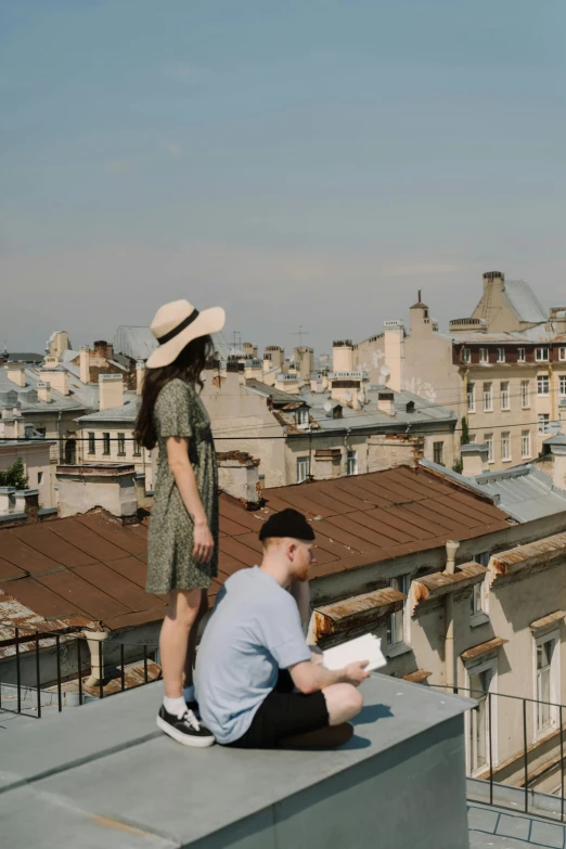 a man and a woman sitting on top of a building, by Zofia Stryjenska, pexels contest winner, reading the book about love, wearing a french beret, gif, alexey gurylev