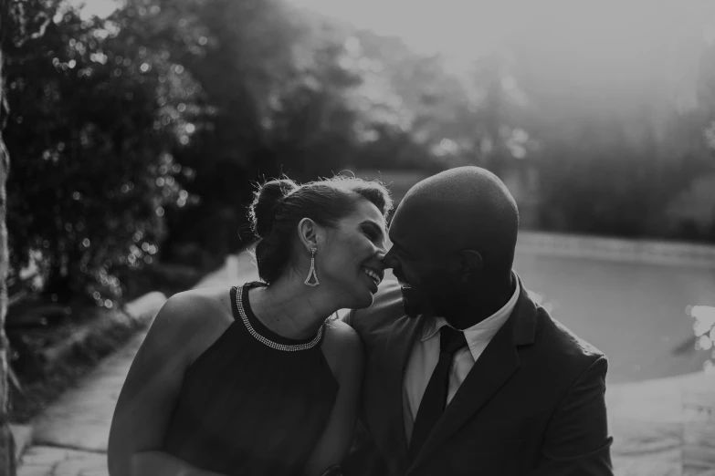 a black and white photo of a man and a woman, a black and white photo, pexels contest winner, renaissance, kissing smile, shaquille o'neil pregnant, black tie, magic hour