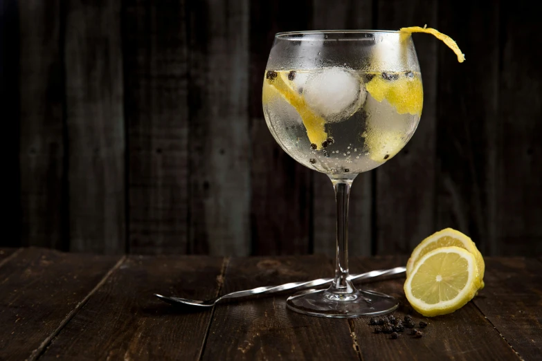 a glass of water sitting on top of a wooden table, inspired by Wlodzimierz Tetmajer, pexels, renaissance, lemons, striking pose, chianti molotov cocktails, white and yellow scheme