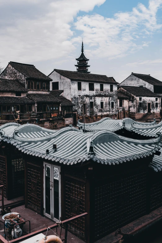 a group of buildings sitting on top of a river, inspired by An Zhengwen, pexels contest winner, mingei, tiled roofs, black roof, 1 7 0 0 s, low quality photo