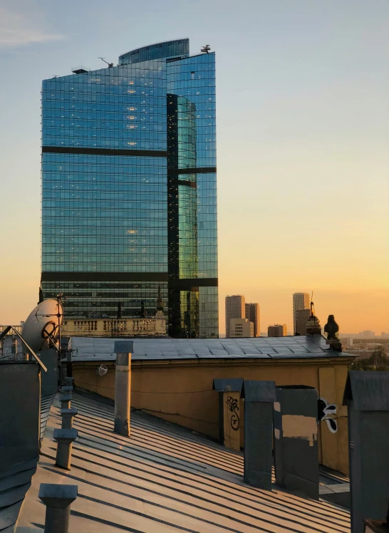 a group of people standing on top of a roof, the building is a skyscraper, during a sunset, slide show, milan jozing