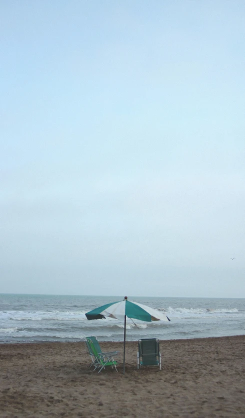 a couple of lawn chairs sitting on top of a sandy beach, an album cover, unsplash, conceptual art, under large green umbrella, rough seas, square, portrait n - 9