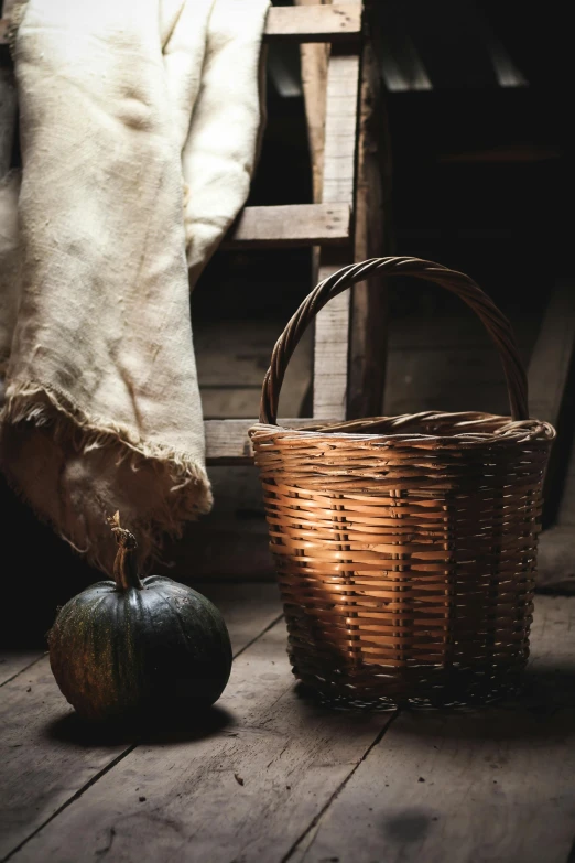 a basket sitting on top of a wooden floor next to a chair, a still life, unsplash, renaissance, pumpkin, walking down, inside a shed, dark. no text