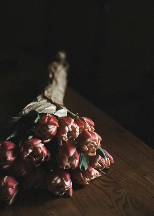 a bunch of flowers sitting on top of a wooden table, a still life, by Eglon van der Neer, unsplash contest winner, romanticism, tulips, medium format. soft light, brown and pink color scheme, stunningly mysterious