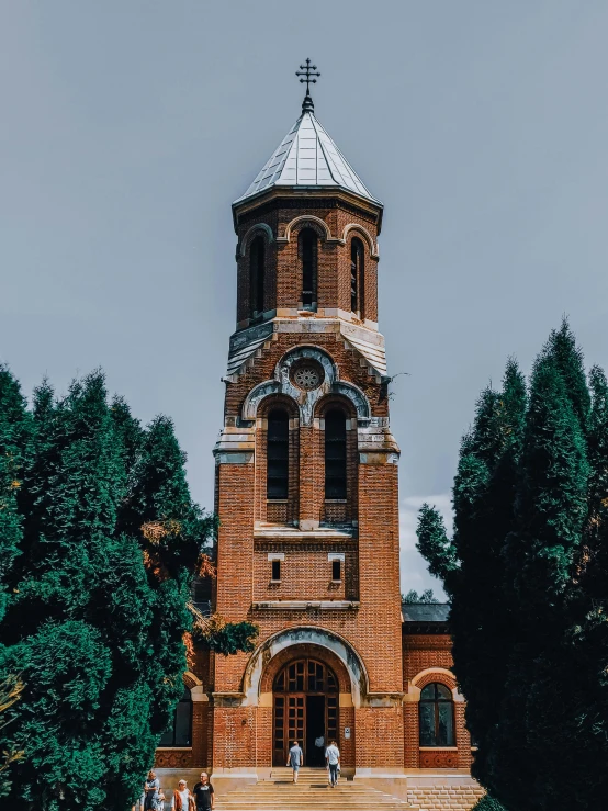 a tall brick building with a clock tower, a photo, pexels contest winner, against the backdrop of trees, holy iconography, university, high quality image