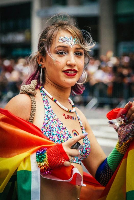 a woman holding a rainbow flag in a parade, a photo, by Scott Samuel Summers, trending on unsplash, renaissance, wearing a dress made of beads, humans of new york, wearing a vest top, handsome girl