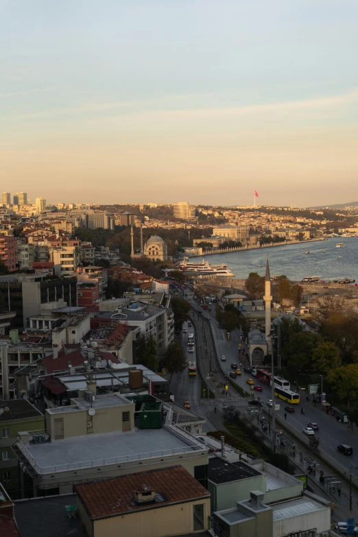 a view of a city from the top of a building, hurufiyya, istanbul, sunset!, half turned around, shoreline