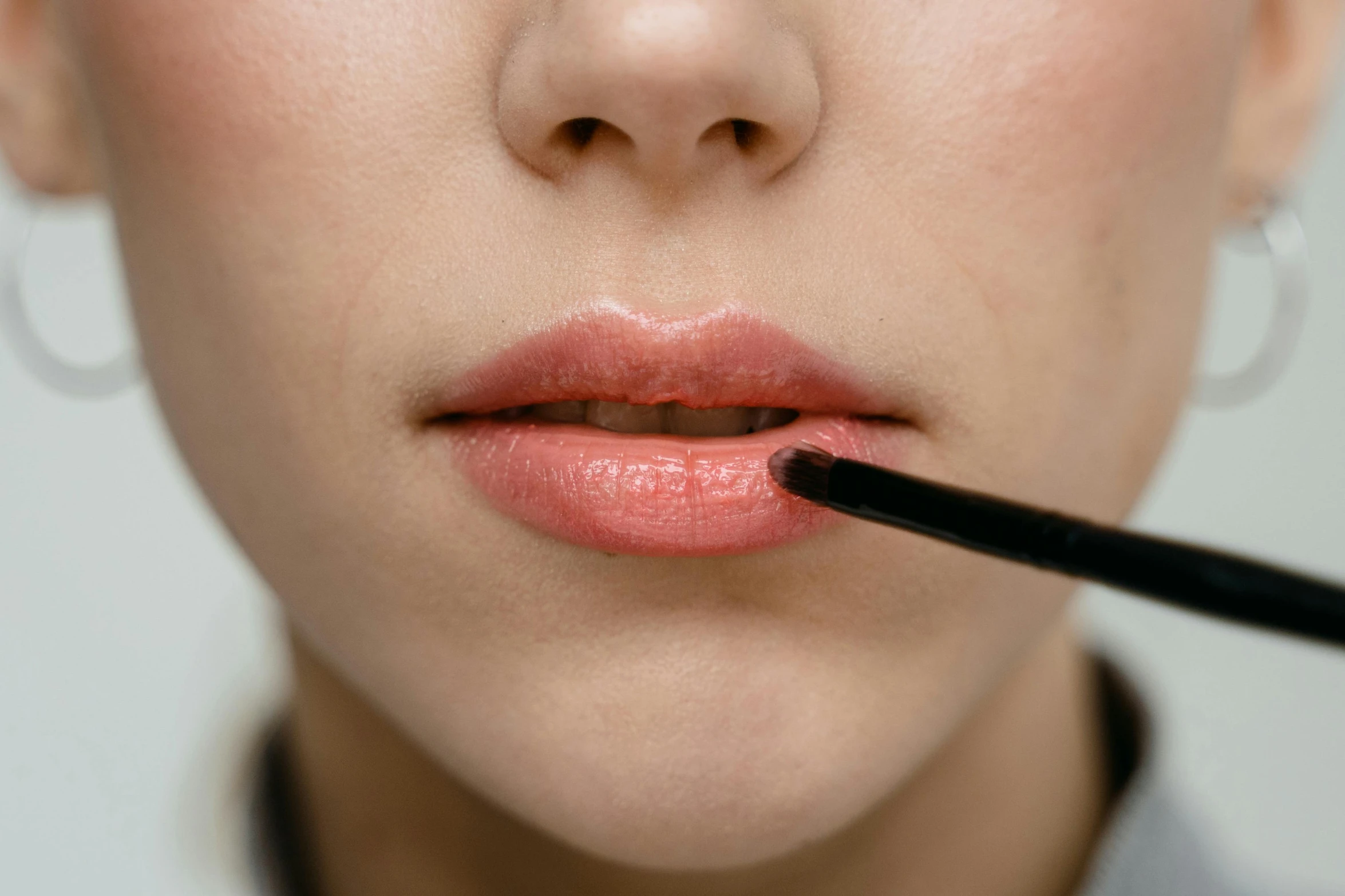 a close up of a woman with a brush in her mouth, inspired by Man Ray, trending on pexels, photorealism, putting on lipgloss, ( ultra realistic, hyperrealistic ”