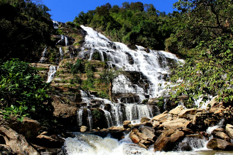 a waterfall in the middle of a lush green forest, hurufiyya, avatar image