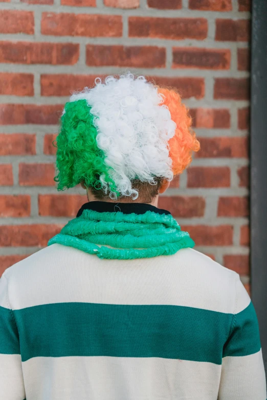 a person standing in front of a brick wall, inspired by William Conor, unsplash, powdered wig, at the world cup, wearing festive clothing, irish