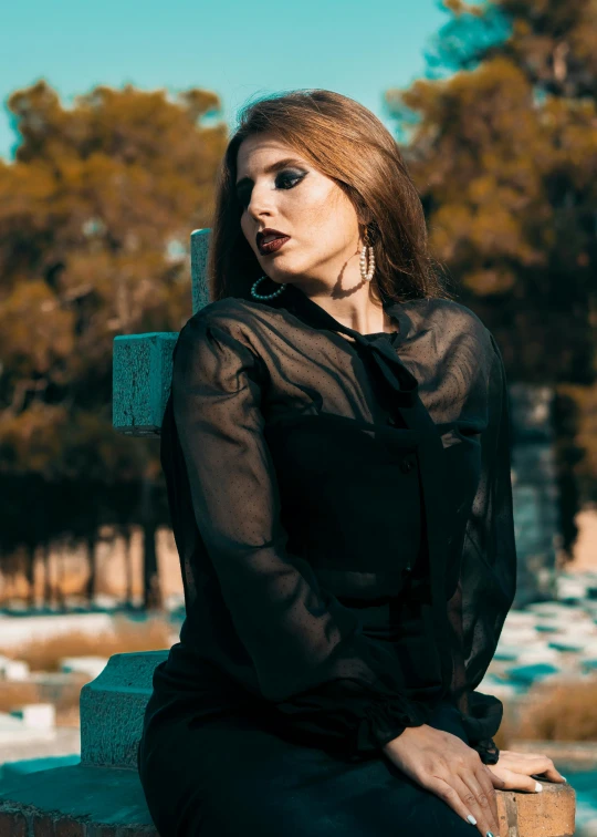 a woman in a black dress sitting on a bench, an album cover, inspired by Elsa Bleda, trending on pexels, gothic art, cemetery, leather clothing, profile image, half image