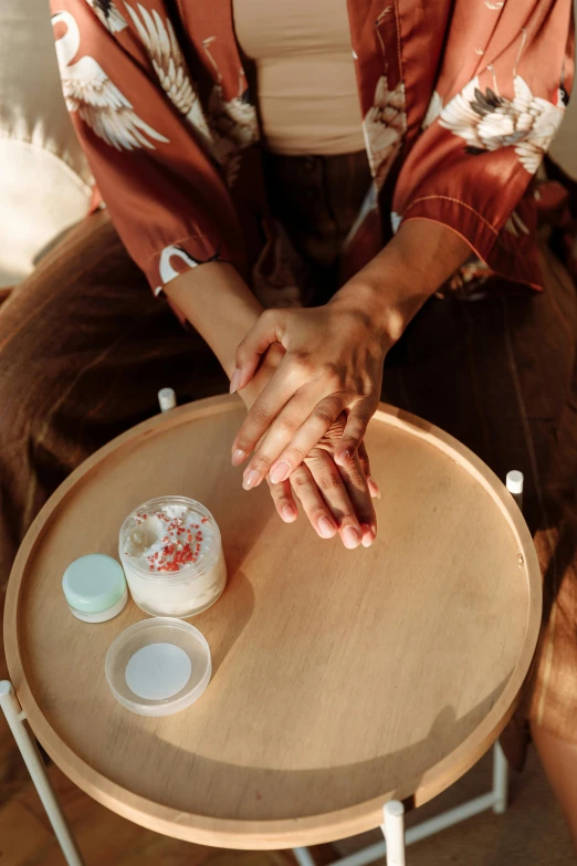 a woman sitting on top of a wooden table, perfect hands, apothecary, silicone skin, circle