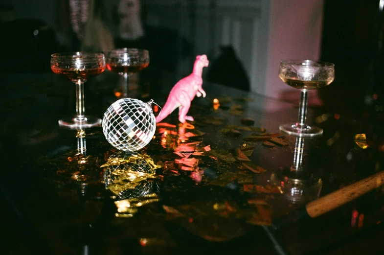 a pink flamingo figurine sitting on top of a table, a hologram, trending on unsplash, holography, drinking a martini, meteor impact behind a dinosaur, large globe, scene from a dinner party