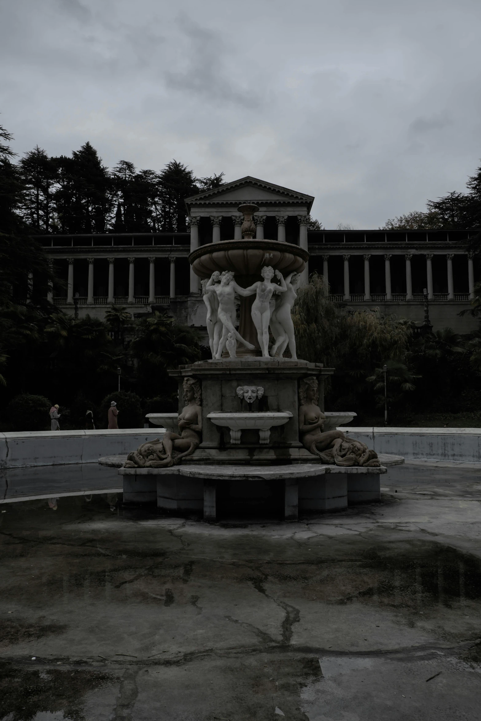 a fountain with statues in front of a building, a statue, dark eerie movie frame, necropolis, low quality photo, madrid