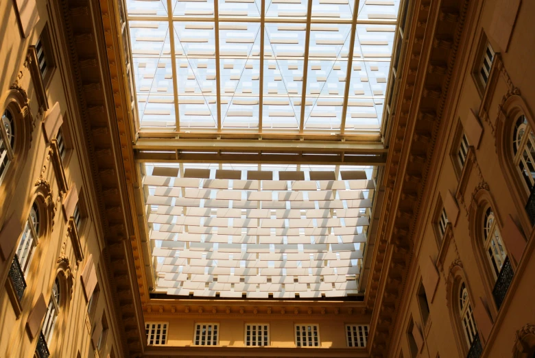 a very tall building with a skylight above it, a portrait, light and space, overhead canopy, neoclassical, squares, brown