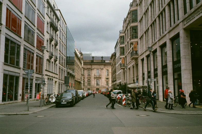 a group of people walking down a street next to tall buildings, inspired by Thomas Struth, pexels contest winner, paris school, berghain, on a great neoclassical square, photo for a store, exterior view