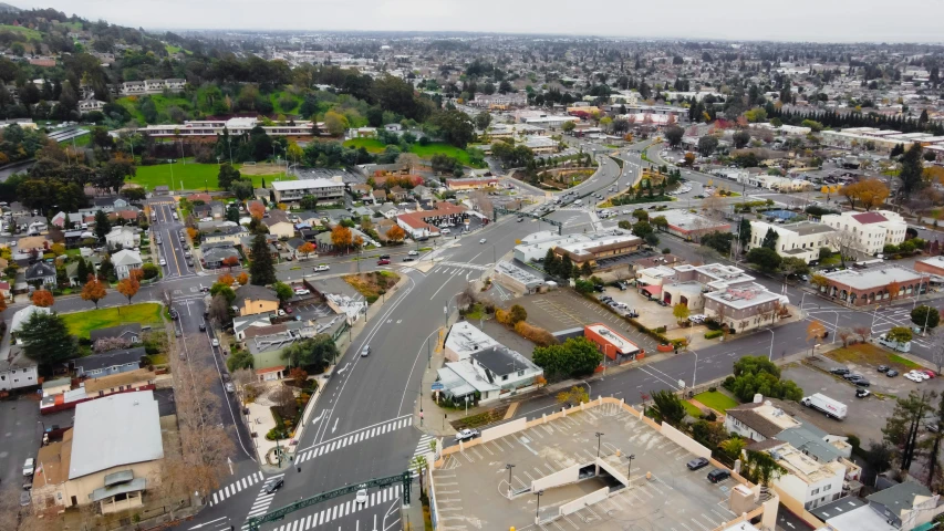 an aerial view of a city with lots of buildings, unsplash, photorealism, vallejo, street corner, in the foreground a small town, background image