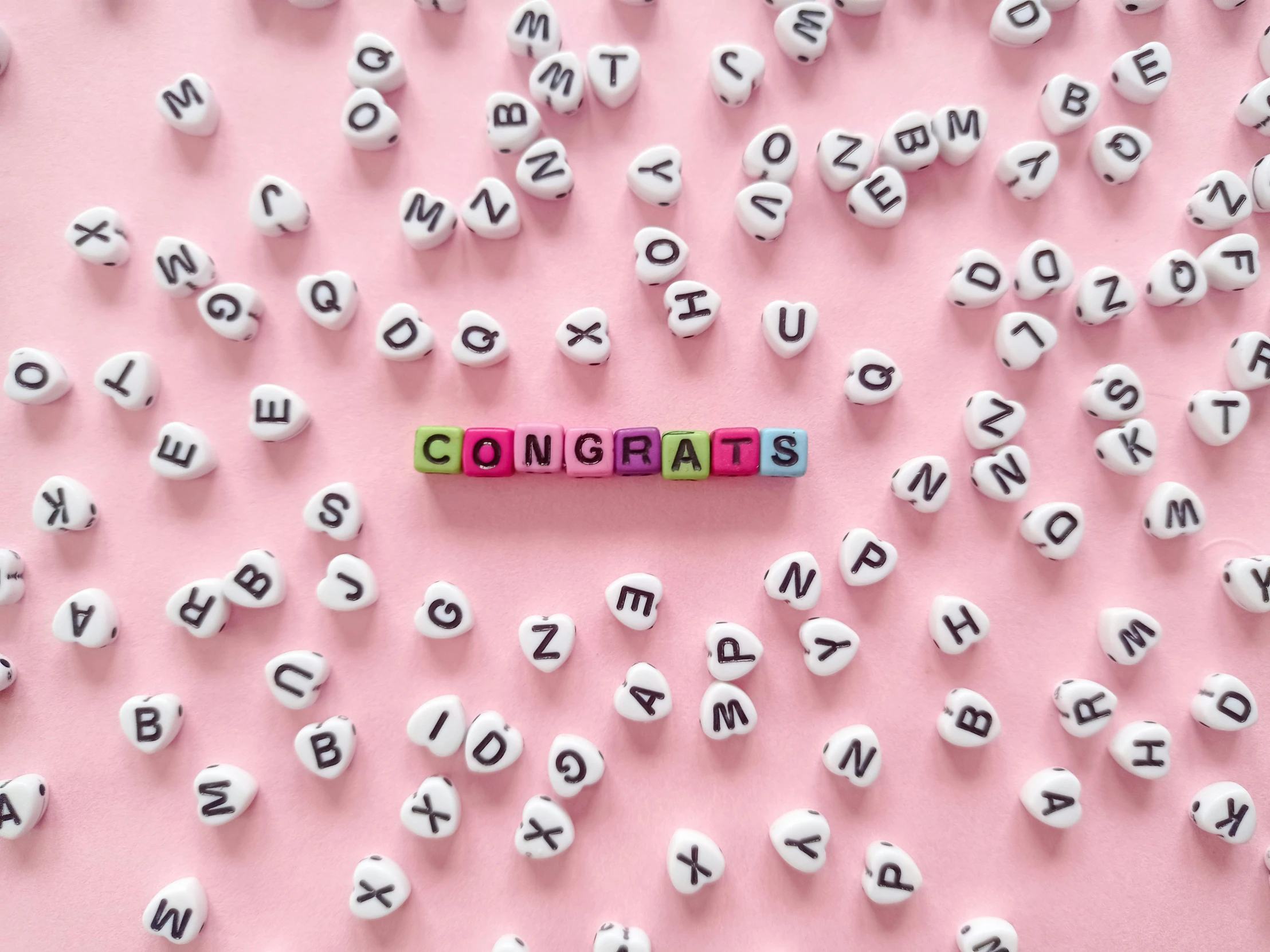 the word congrats spelled in wooden letters on a pink background, by Emma Andijewska, pexels contest winner, letterism, miniatures, bubble letters, pregnancy, 🌻🎹🎼