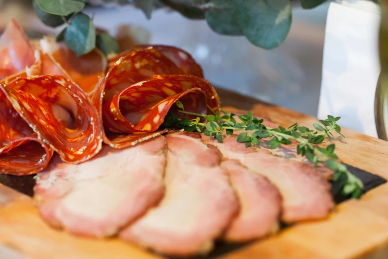 a wooden cutting board topped with sliced meat, by Tom Bonson, pexels contest winner, renaissance, straya, smoked layered, ivy's, ham