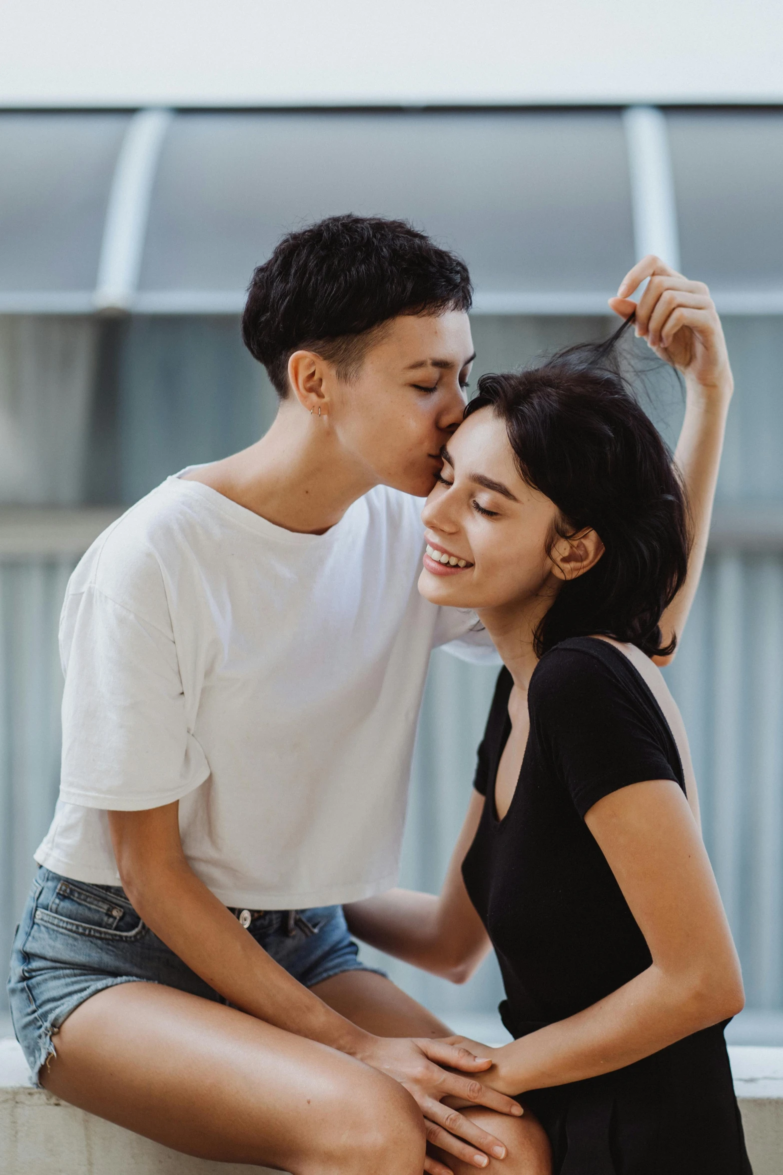 a man and a woman sitting next to each other, by Cosmo Alexander, trending on pexels, lesbian kiss, buzzed hair on temple, couple dancing, yael shelbia