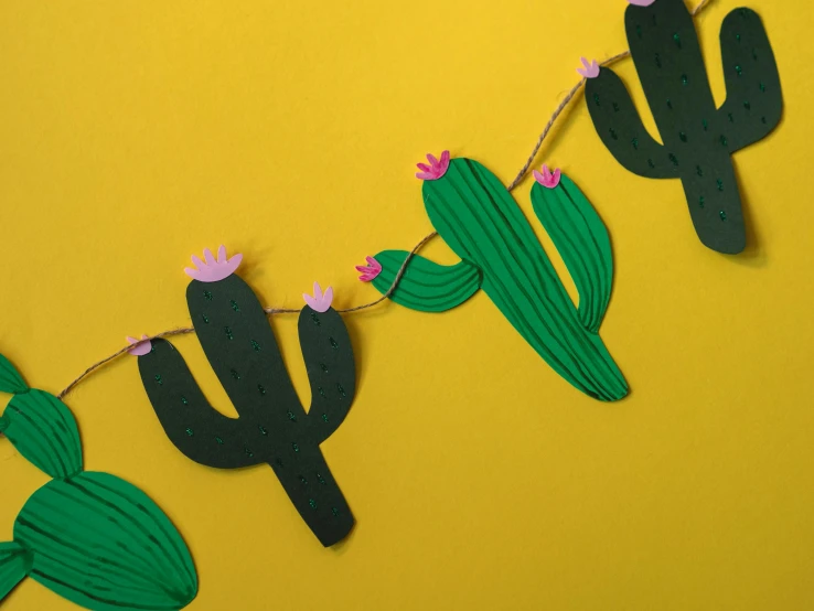 a paper cactus garland on a yellow background, by Liza Donnelly, trending on pexels, on grey background, detailing, high, laser cut