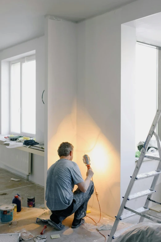 a man is painting a room with a ladder, a photo, arbeitsrat für kunst, sconces, electrical, banner, wiring