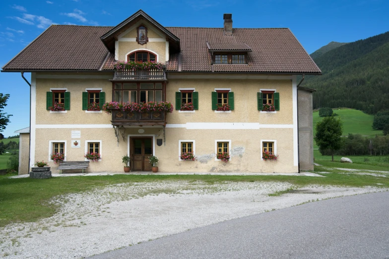 a large house sitting on the side of a road, inspired by Rudolf von Alt, renaissance, dolomites, exterior photo, square, preserved historical