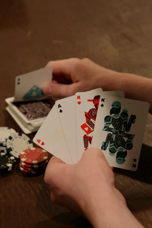 a close up of a person holding playing cards, a screenshot, by Sam Black, pexels contest winner, board games on a table, chips, robotics, striking pose