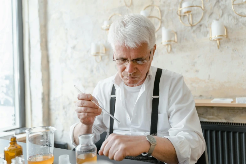 a man sitting at a table in front of a plate of food, beakers, white hair color, filling with water, carefully crafted
