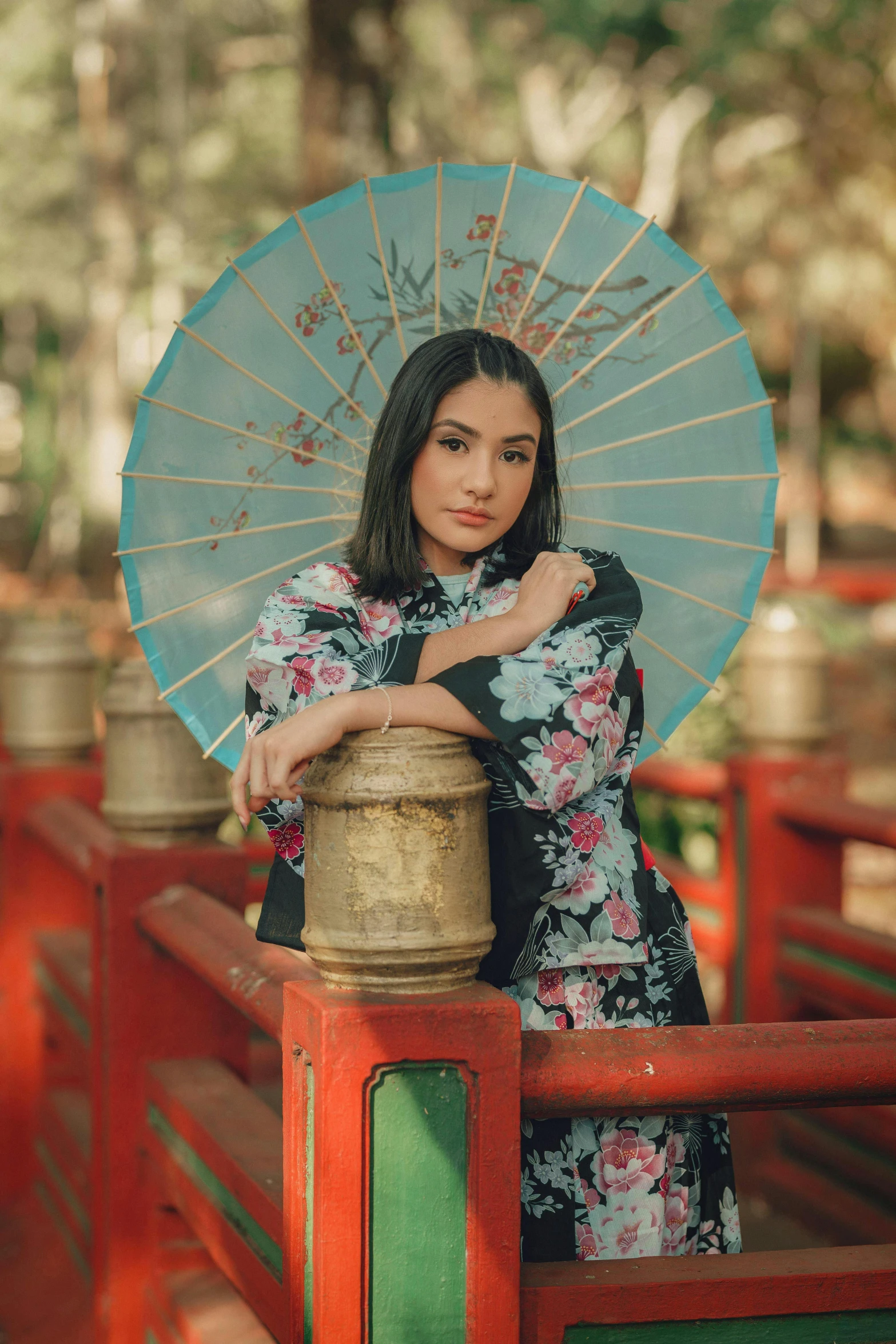 a woman standing on a bridge holding an umbrella, inspired by Ju Lian, pexels contest winner, realism, looking the camera, traditional beauty, malaysian, square