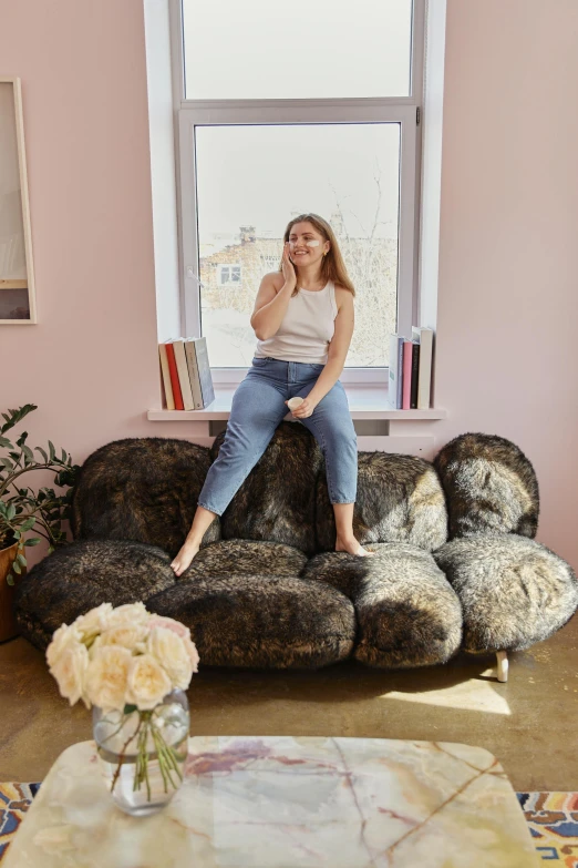 a woman sitting on a couch in a living room, by Nina Hamnett, giant rocks, yulia nevskaya, foam, big floppa