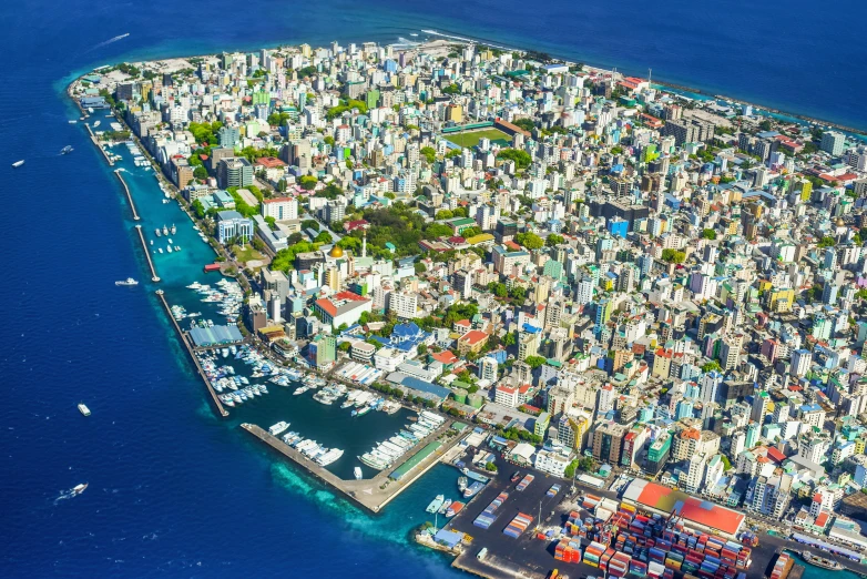 an aerial view of a city in the middle of the ocean, hurufiyya, maldives in background, high quality product image”