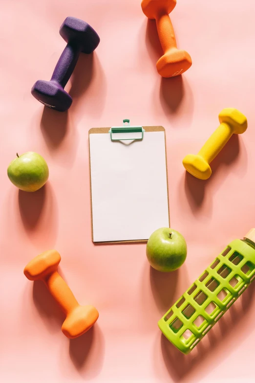 a clipboard, dumbbells, and an apple on a pink surface, multiple stories, thumbnail, snacks, brightly lit