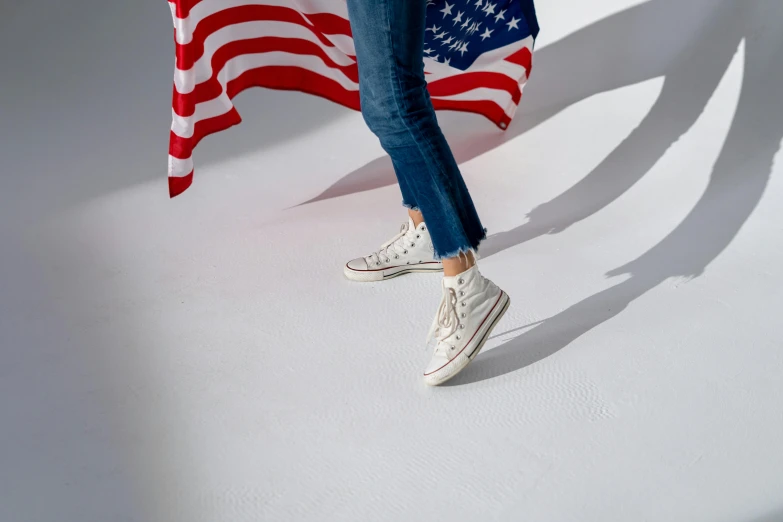 a woman standing in front of an american flag, wearing white sneakers, white metallic, mini model, a wide shot