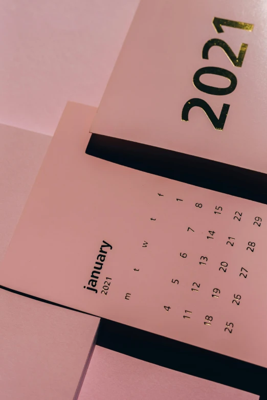 a calendar sitting on top of a desk next to a pen, trending on pexels, happening, pink background, thumbnail, stacked image, 27