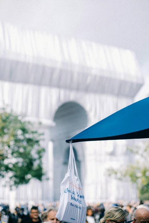 a group of people standing under a blue umbrella, upclose, architectural shot, commercial banner, viewed from a distance