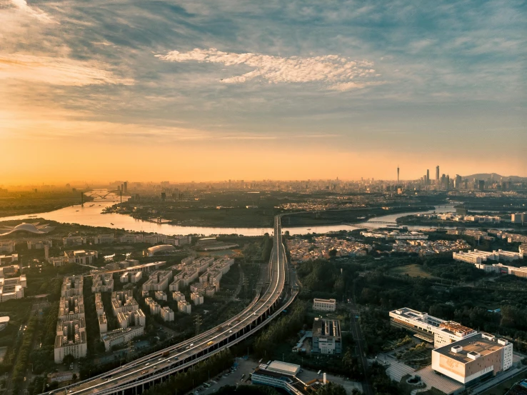 an aerial view of a city at sunset, by Zha Shibiao, pexels contest winner, happening, wide angle river, panoramic widescreen view, slide show, cinematic silk road lanscape