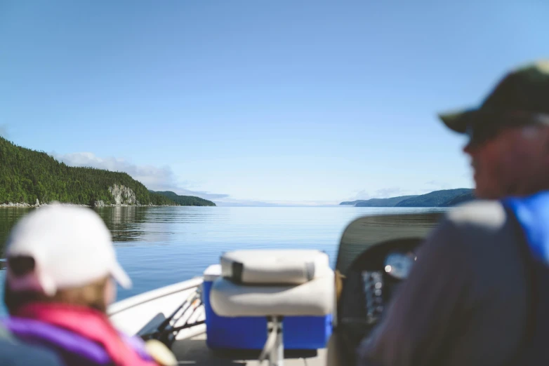 a group of people riding on the back of a boat, by karlkka, pexels contest winner, detailed lake in background, quebec, looking off into the distance, british columbia