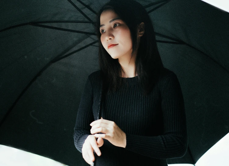 a close up of a person holding an umbrella, dark black hair, wearing a black sweater, asian women, portrait featured on unsplash