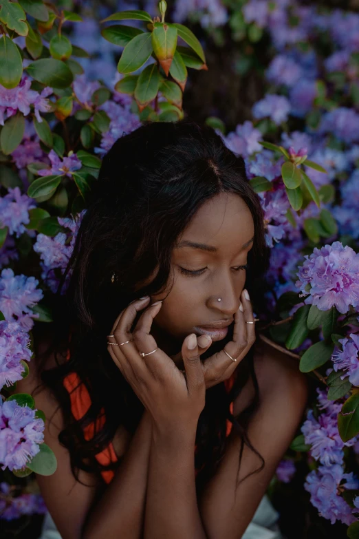 a woman sitting in a field of purple flowers, an album cover, by Dulah Marie Evans, trending on unsplash, with brown skin, shy looking down, sza, photo of a hand jewellery model