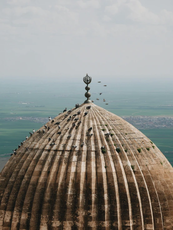 a large dome sitting on top of a lush green field, by Abdullah Gërguri, unsplash contest winner, flying birds in distance, trampling an ancient city, bird\'s eye view, instagram story