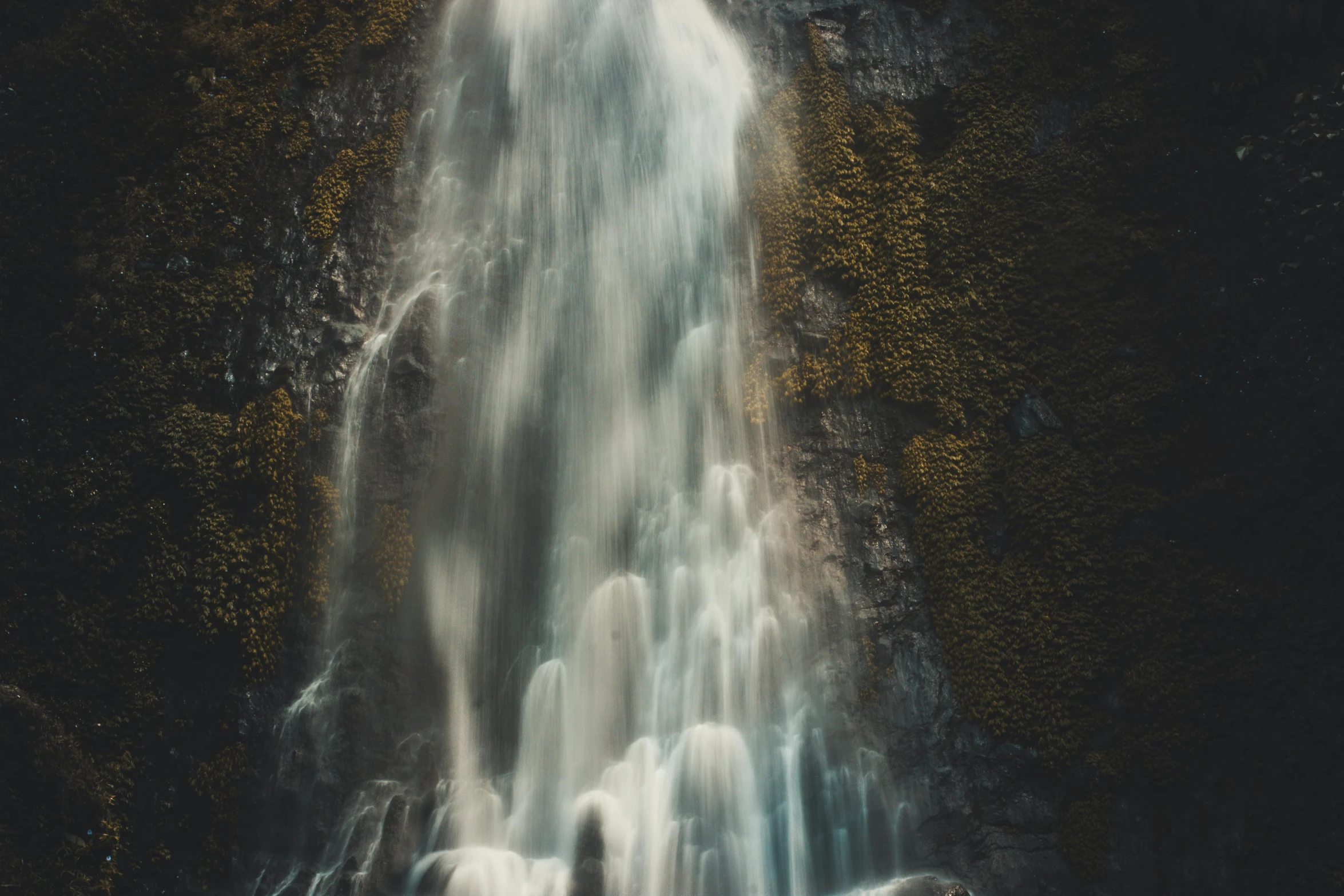 a person standing in front of a waterfall, a tilt shift photo, by Matthias Weischer, unsplash contest winner, hurufiyya, ethereal curtain, medium format. soft light, by emmanuel lubezki, high - angle view