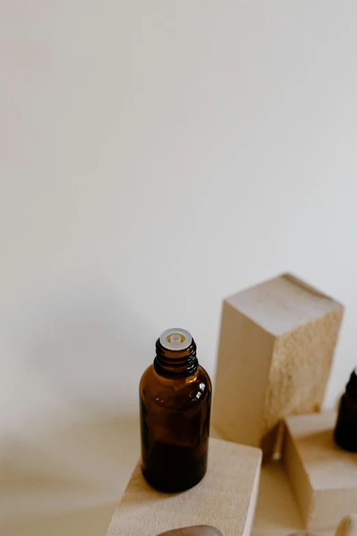 a bottle of essential oil sitting on top of a wooden block, by Carey Morris, trending on pexels, minimal design, thumbnail, 8, jovana rikalo