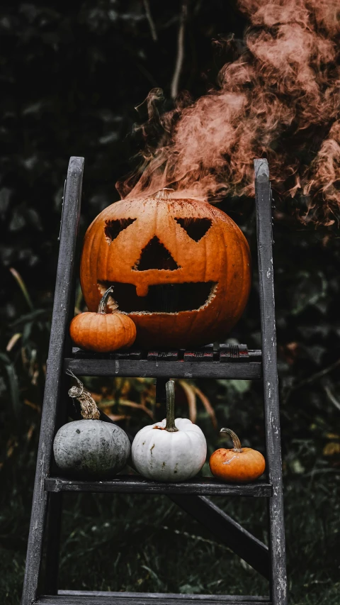 a pumpkin sitting on top of a wooden ladder, by Jesper Knudsen, pexels, smoke grenades, gif, low quality photo, beistle halloween decor