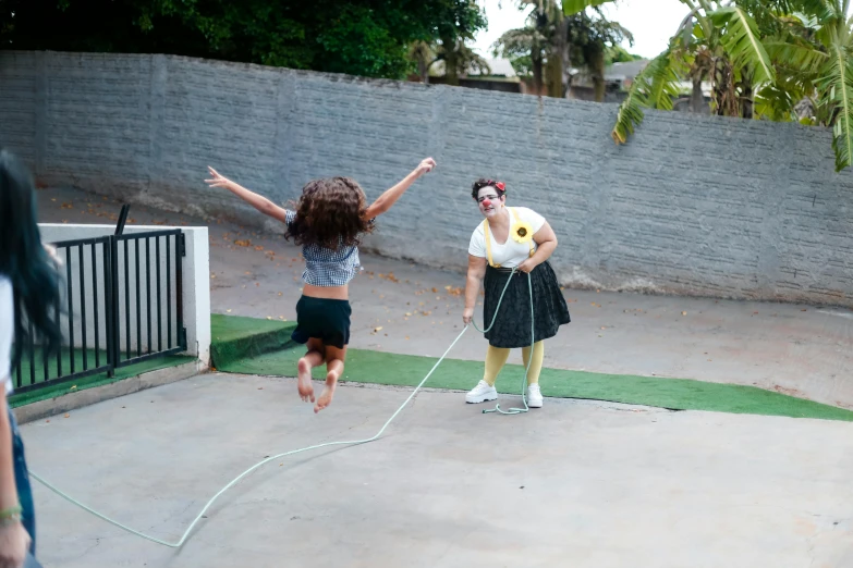 a group of people playing a game of frisbee, an album cover, by The Family Circus, pexels contest winner, figuration libre, hoses, jump, justina blakeney, on the concrete ground