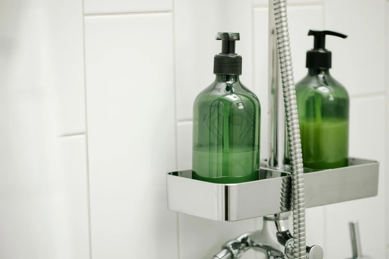 a bath room with a sink and a soap dispenser, by Daarken, unsplash, bright castleton green, detail shot, bottles, angled